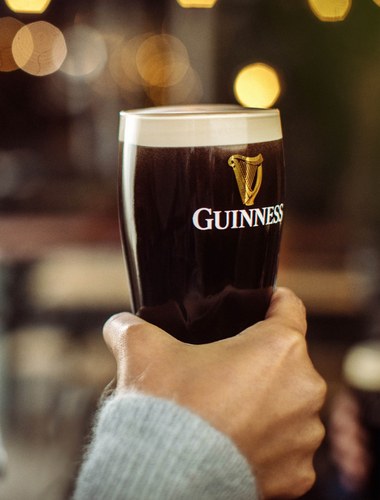 Customer holding pint of Guinness